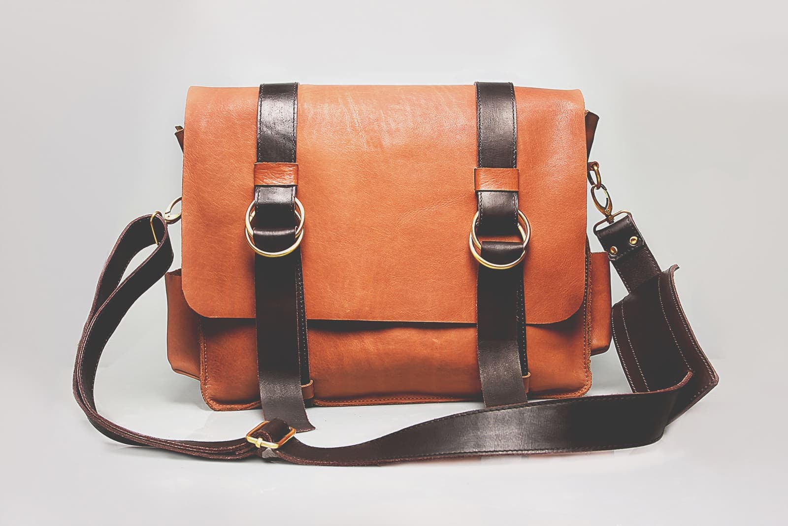 A tan leather briefcase resting against a neutral background