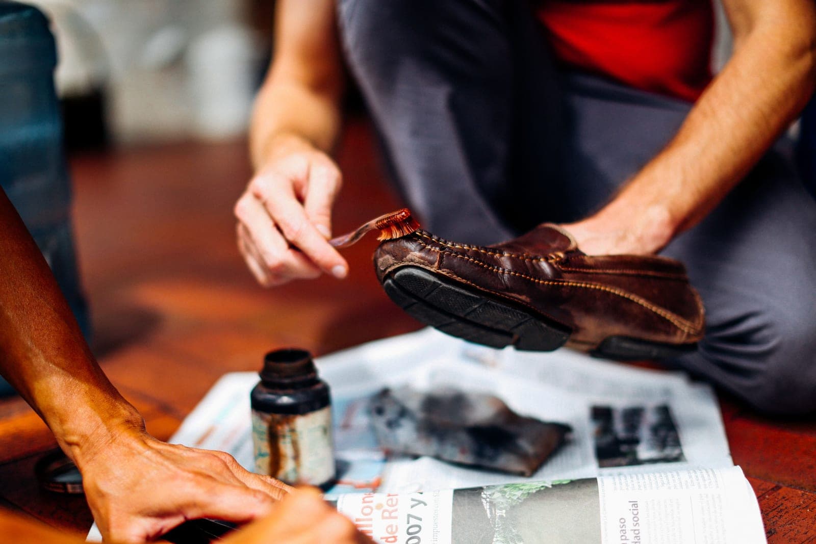 A cloth and conditioner being worked into brown leather