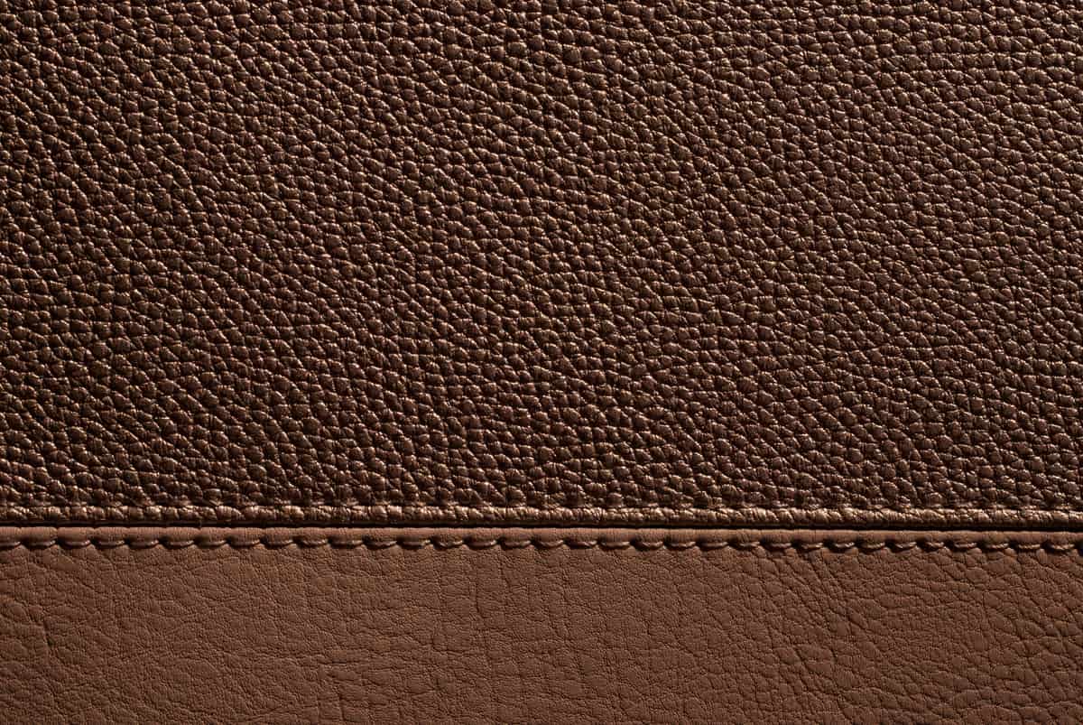 Well-worn brown leather that has darkened into a rich patina