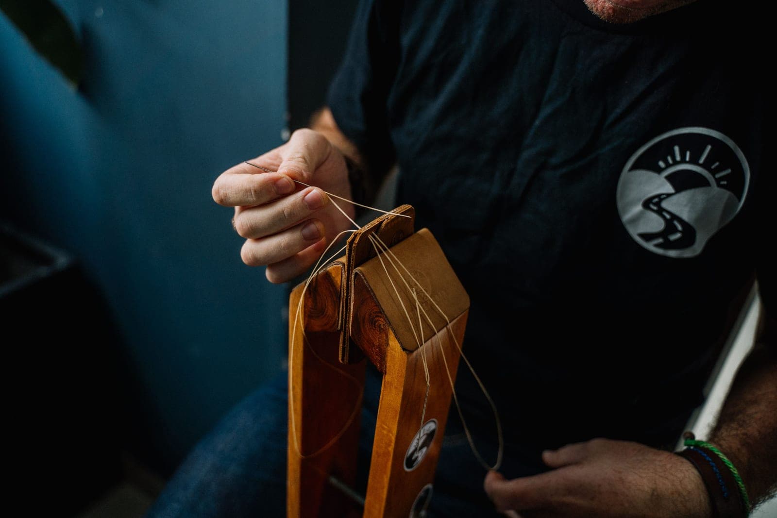 Close-up of hand-stitched saddle stitching along a leather edge