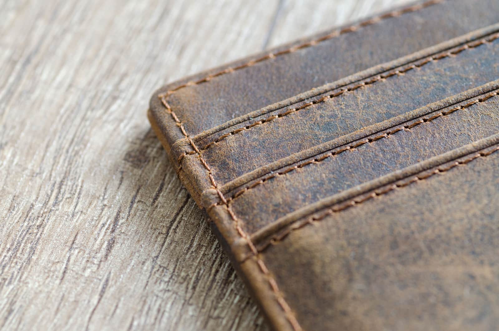 A brown leather bifold wallet with visible grain and stitching